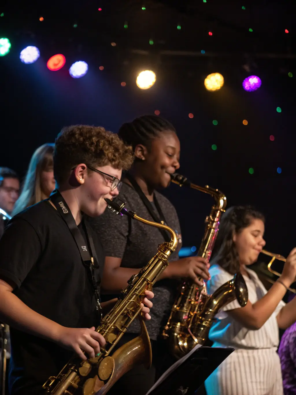 A group of young students enthusiastically playing various musical instruments together in a classroom setting, showcasing teamwork and musical skill development.